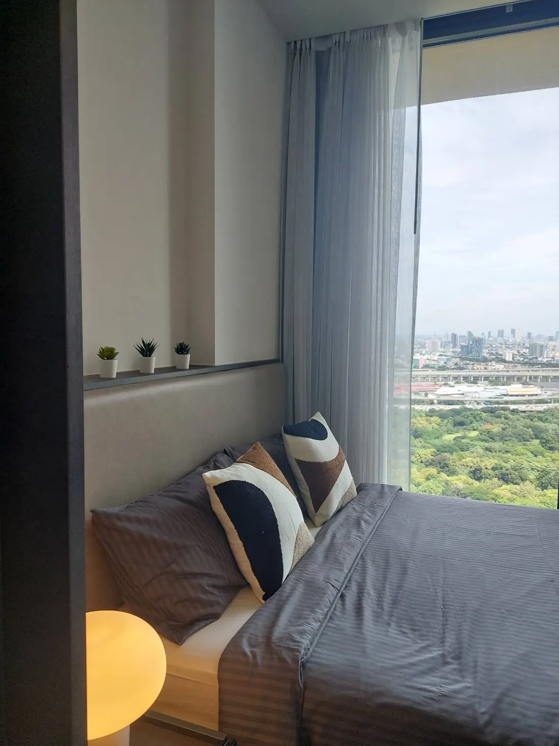 ห้องนอนวิวเมืองพร้อมผ้าม่านโปร่ง